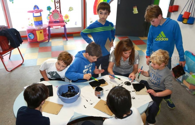 ninos pintando con pintura negra unos cuadros.jpg